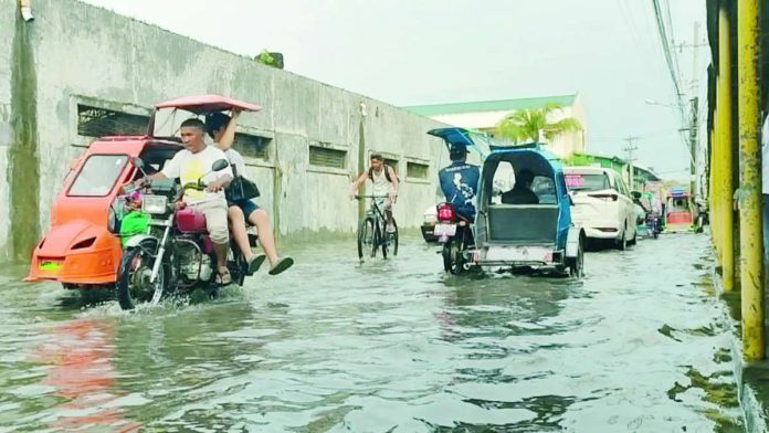 neljoy_leptos_copy_compressed_resized Motorists, cyclists and tricycle drivers carefully make their way through floodwaters along a flooded street in Iloilo City after recent heavy rains, underscoring the continuing risk of urban flooding and the need for residents to remain vigilant against waterborne diseases such as leptospirosis. AJ PALCULLO/PN