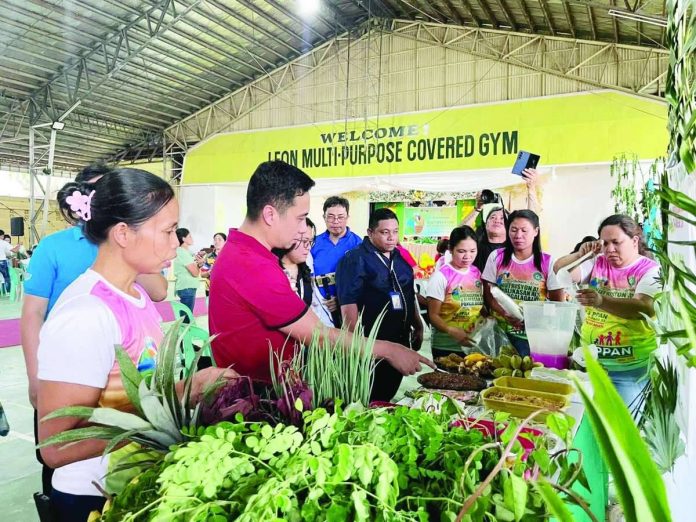 neljoy_nutri_compressed_resized Participants and guests view an exhibit showcasing locally grown fruits, vegetables and other nutritious food products during the opening of the 52nd Regional Nutrition Month celebration at the Leon Multi-Purpose Covered Gym in Leon, Iloilo. NNC REGION 6
