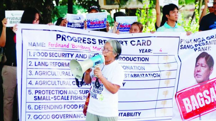 neljoy_peasant1_copy_compressed_resized PROGRESS REPORT. Peasant leaders from Panay and Guimaras islands present a symbolic “progress report card”, giving President Ferdinand “Bongbong” Marcos Jr.’s administration failing marks on key agriculture and fisheries issues, including food security, land reform, climate resiliency, protection of small-scale fisheries, and governance.