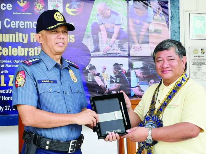 Iloilo City Police Office director Colonel Wilbert B. Parilla (left) presents a token to MORE Electric and Power Corporation president and chief executive officer Roel Z. Castro during the culmination ceremony of the 31st Police Community Relations Month on July 27, 2026. Castro praises the ICPO for a significant drop in local crime rates while highlighting the effective partnership between law enforcement and the power distribution utility.