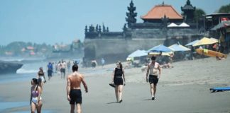 Tourists walk on a beach in Bali, where its usually bustling beaches turn empty during Nyepi, an annual Hindu holiday. AFP VIA GETTY IMAGES