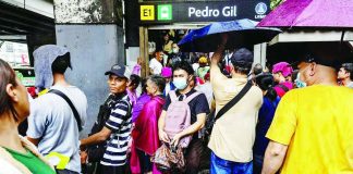 People enter and exit an LRT-1 station in floodwaters during heavy monsoon rains in Manila, August 17, 2026. REUTERS/ Eloisa Lopez
