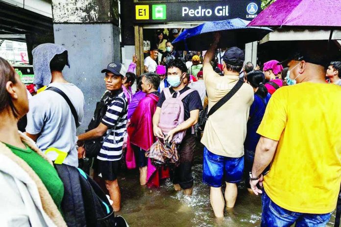 DOLE_No_liability_compressed_resized People enter and exit an LRT-1 station in floodwaters during heavy monsoon rains in Manila, August 17, 2026. REUTERS/ Eloisa Lopez