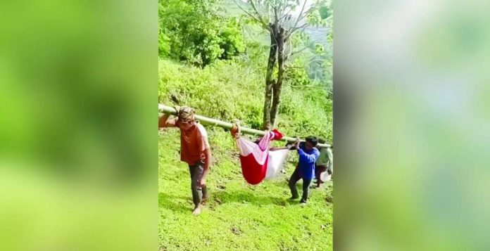 DSWD UPLIFT 2_compressed_superimposed A physically incapacitated UPLIFT beneficiary was carried by relatives using a bamboo pole and blankets to a payout venue in Barangay Bi-ao, Binalbagan, Negros Occidental, as shown in a viral video. The DSWD-NIR clarified that beneficiaries who are unable to travel may have a qualified family member claim the assistance on their behalf. SCREENGRAB FROM MARVIE FABURADA FB