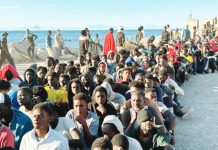 EU commends Spain’s swift response to Ceuta migrant crisis Migrants sit on the ground in rows at the beach with the sea behind them in Ceuta, Spain waiting for aid. GETTY IMAGES
