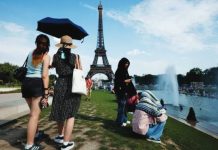 Heatwaves blamed for sharp rise in drownings Women shelter from the heat under a black umbrella at the Trocadero Fountain by the Eiffel Tower, in Paris, France. Other people are seated next to the river. EPA
