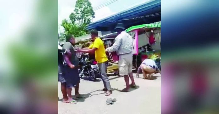 Himamaylan assault_superimposed Bystanders and fellow tricycle drivers restrained a tricycle driver after he allegedly punched a traffic enforcer during a confrontation over a roadside parking violation behind Himamaylan Central School in Himamaylan City on August 19. The traffic enforcer is seen on the ground following the alleged assault. The Land Transportation Office–Negros Island Region later served a Show Cause Order on the driver. SCREENGRAB FROM PANAY NEWS DIGITAL