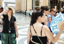 Italy putting nearly all major cities on highest heat alert People drink water and use hand fans to protect themselves from the sun in Naples, southern Italy. Italian health officials urge residents in the affected areas to avoid exposure to heat direct sunlight by staying indoors and drinking plenty of fluids. ANADOLU VIA GETTY IMAGES