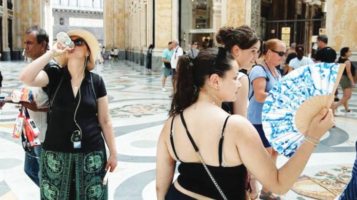 Italy People drink water and use hand fans to protect themselves from the sun in Naples, southern Italy. Italian health officials urge residents in the affected areas to avoid exposure to heat direct sunlight by staying indoors and drinking plenty of fluids. ANADOLU VIA GETTY IMAGES