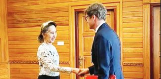 Former Myanmar president Aung San Suu Kyi shakes hands with Arnaud de Baecque, resident representative of the International Committee of the Red Cross. Suu Kyi's son has mounted an international campaign demanding proof of life for the detained democracy icon. MYANMAR MILITARY INFORMATION COMMITTEE
