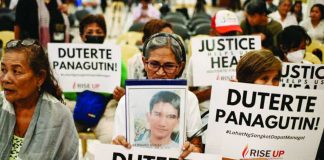 Relatives of war on drugs victims hold placards calling for justice. Former president Rodrigo Duterte faces a crimes against humanity charge at the International Criminal Court over the drug war killings. REUTERS