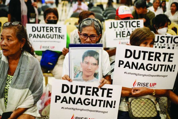 Nation_ICC_copy_compressed_resized Relatives of war on drugs victims hold placards calling for justice. Former president Rodrigo Duterte faces a crimes against humanity charge at the International Criminal Court over the drug war killings. REUTERS