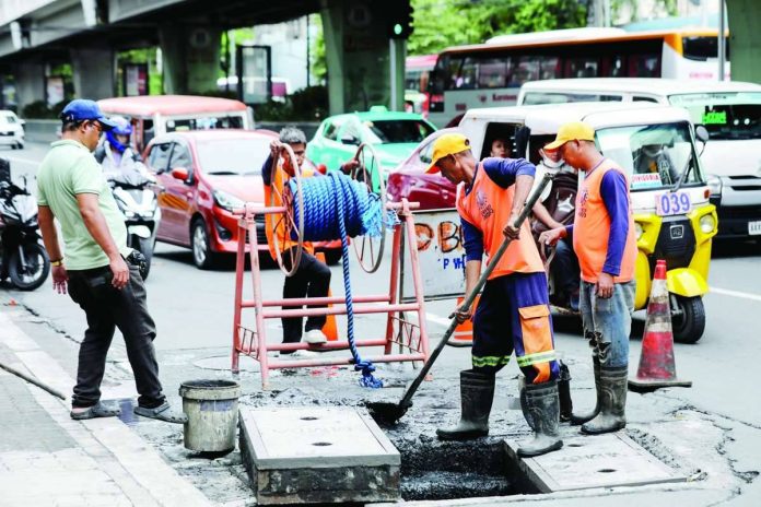 Nation_wage_hike_compressed_resized Workers declog a drainage along Taft Avenue in Manila. The Regional Tripartite Wages and Productivity Board-National Capital Region approved a P85 daily wage increase for NCR workers after consultations among labor, business, and government representatives. PNA