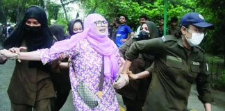 A protester is detained as others gather in support of the banned Joint Awami Action Committee (JAAC), an alliance of Kashmir's civil society groups, during a demonstration in Lahore, Pakistan. EPA