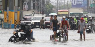 A rider pushes his motorcycle through flooded Aguinaldo Highway in Bacoor, Cavite in this photo taken on August 9, 2026. Continuous monsoon rains inundated several areas in Luzon early this August. PNA
