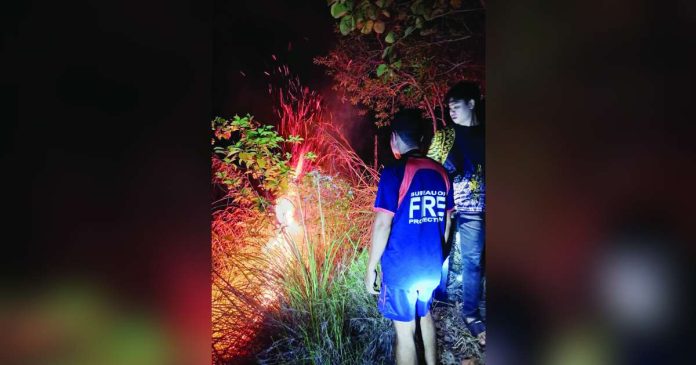 grassfire_compressed_superimposed Firefighters from the Bureau of Fire Protection-Bugasong monitor flames during a grassfire response in a mountainous area of Barangay Lacayon, Bugasong, Antique on Wednesday night, August 20, 2026. BFP-BUGASONG PHOTO