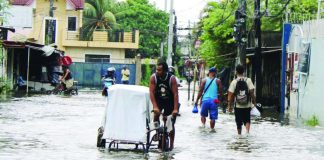 WADING THROUGH ‘HABAGAT.’ Residents navigate a flooded street in La Paz, Iloilo City as persistent rains brought by the southwest monsoon, or habagat, continue to affect Western Visayas. The state weather bureau warned that days of rainfall have saturated the ground and waterways, increasing the risk of flooding and rain-induced landslides, particularly in low-lying and vulnerable communities. ALLEN ANIMAS/PN