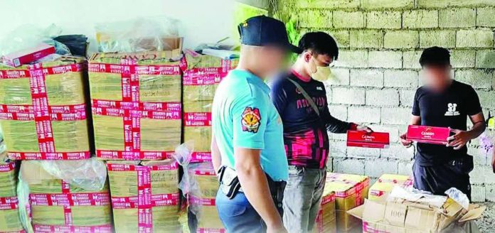 illicit_cigs_compressed_resized Patnongon police officers inspect boxes containing 900 reams of "Cannon" brand cigarettes valued at around P900,000 following an anti-smuggling operation in Barangay Apgahan, Patnongon, Antique, on August 29, 2026. PHOTO COURTESY OF PRO-6