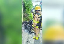 A firefighter from the Bureau of Fire Protection (BFP) – Bacolod City inspects the charred frame of a motorcycle along Saint Francis Street, Doña Juliana Subdivision, Barangay Taculing, Bacolod City on Monday, August 24, 2026. No injuries were reported in the incident. BFP-BACOLOD CITY PHOTO