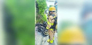 A firefighter from the Bureau of Fire Protection (BFP) – Bacolod City inspects the charred frame of a motorcycle along Saint Francis Street, Doña Juliana Subdivision, Barangay Taculing, Bacolod City on Monday, August 24, 2026. No injuries were reported in the incident. BFP-BACOLOD CITY PHOTO
