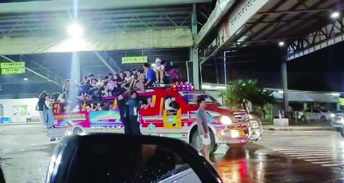 Passengers crowd the roof and cling to the sides of an overloaded jeepney during its “last trip” from Pavia to Lambunao, Iloilo on July 31. A netizen’s video of this jeepney went viral and caught the attention of the Land Transportation Office. MA. FE EGALAM ALVAREZ/FACEBOOK
