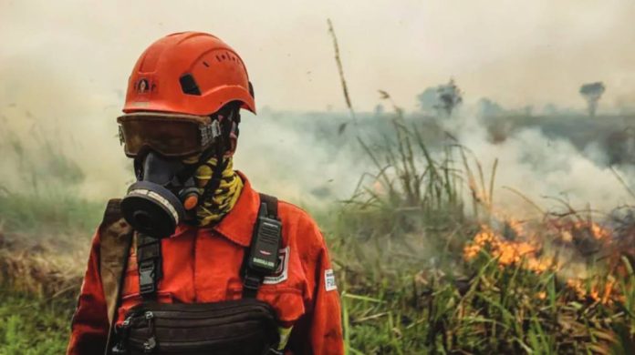 Indonesia A person in firefighting uniform, helmet and gas mask stands amid smoke in front of flaming grass. As wildfires worsen across large parts of Indonesia, a noxious haze is choking the region. GETTY IMAGES