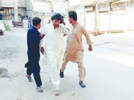 Three men move quickly on a road after a blast occurred at a mosque building near police headquarters in Pakistan. REUTERS
