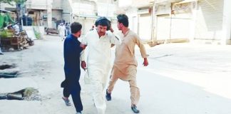 Three men move quickly on a road after a blast occurred at a mosque building near police headquarters in Pakistan. REUTERS