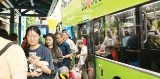 Playing loud music on Singapore buses will now cost you hundreds of dollars in fines A small crowd of people alight from a green double-decker bus in Singapore. GETTY IMAGES