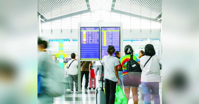 airfares higher_compressed_superimposed Passengers check flight schedules at the Ninoy Aquino International Airport departure area as they prepare to head off to their next destinations. NAIA/FACEBOOK PHOTO