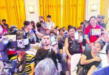 Beneficiaries of the Unified Package for Livelihoods, Industry, Food, and Transport (UPLIFT) program display their mobile phones showing the financial aid received via e-wallet during the pilot launch of the DSWD digital payout system at the Bacolod City Government Center lobby on Sept. 22.