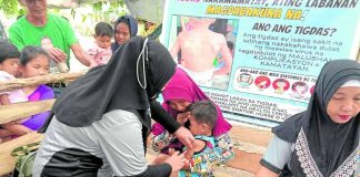 A barangay health worker gives a boy his measles vaccine shot as part of the government’s mass vaccination campaign in the Bangsamoro Autonomous Region in Muslim Mindanao. PHOTO COURTESY OF RURAL HEALTH UNIT PAGALUNGAN