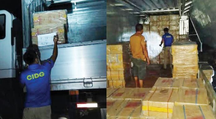 Operatives of the CIDG-Negros Occidental Provincial Field Unit inspect master cases of illicit cigarettes and cargo inside a wing van truck following a buy-bust operation in Barangay 3, Isabela, Negros Occidental, early Friday morning, September 25. The operation led to the arrest of three suspects. CIDG PHOTOS
