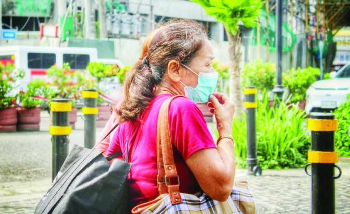 A pedestrian wears a face mask while walking along Plazoleta Gay in Iloilo City on Thursday, Sept. 3. Ambient air quality in the city on Sept. 4 reached “unhealthy for sensitive groups” levels, prompting health advisories for children and adults with respiratory conditions to take precautions against transboundary haze from Indonesia. ALLEN ANIMAS/PN