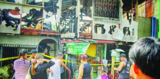 Residents gather outside a gutted residential property on Wednesday morning, Sept. 2, 2026, following a late-night fire in Zone 8, Barangay Veterans Village, City Proper, Iloilo City. The fire damaged nine residential structures, displaced 13 families, and injured four individuals. ALLEN ANIMAS/PN