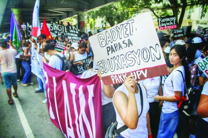 neljoy_SUC_funding_copy_compressed_resized Youth and student groups join a protest in Iloilo City, with one demonstrator carrying a placard reading “Badyet Para sa Edukasyon,” as they call attention to public education funding and government spending priorities. The mobilization comes amid concerns over a reported P33-billion funding gap between the proposed budgets of state universities and colleges in Western Visayas and the allocation under the proposed 2027 national budget. ALLEN ANIMAS/PN