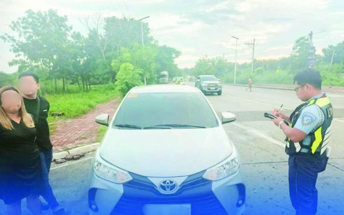 neljoy_colorum_copy_compressed_resized An enforcement officer of the Land Transportation Office - Region 6 inspects a sedan intercepted along the Circumferential Road in Barangay Buhang, Jaro, Iloilo City for allegedly transporting paying passengers without the required franchise. LTO has apprehended 188 “colorum” vehicles across Western Visayas since January as it intensifies its campaign against unauthorized passenger transport. LTO-6