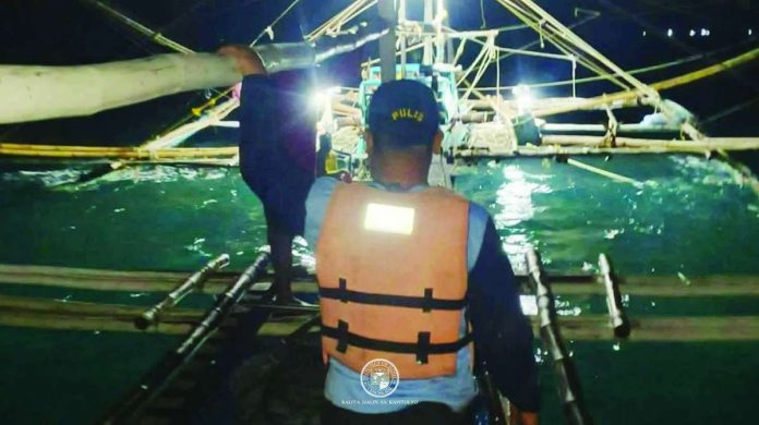 A member of the Iloilo Provincial Bantay Dagat Task Force approaches one of two fishing boats intercepted for alleged “siklob” fishing off Concepcion, Iloilo. PHOTO FROM ILOILO PROV’L ADMINISTRATOR RAUL BANIAS