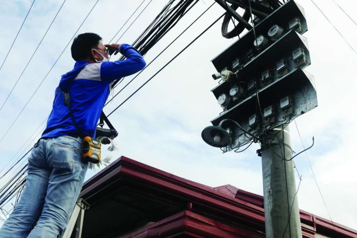 power_consumers_savings_compressed_resized An electric cooperative worker uses a ladder to get up to read the electric. The Department of Energy welcomes Bureau of Internal Revenue’s removal of the value-added tax on system loss. PNA PHOTO BY OLIVER MARQUEZ