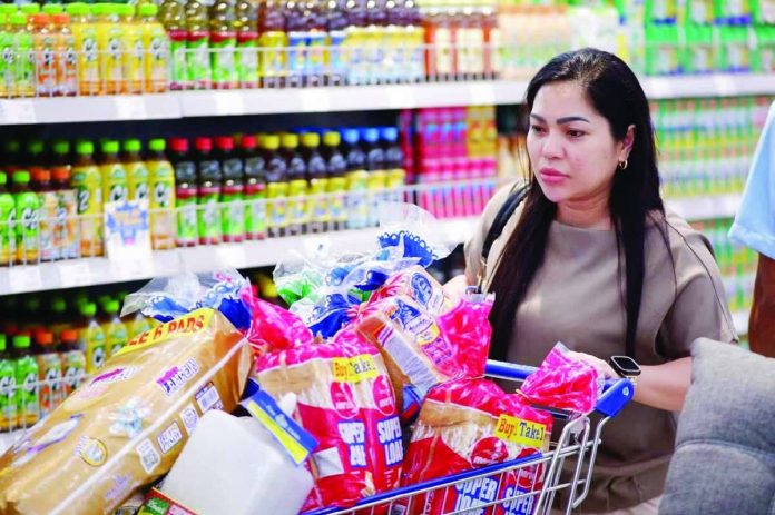 A shopper checks out essential household items and grocery staples at SM Supermarket. The Department of Finance had suggested increasing the tax on sugary drinks with caloric or noncaloric sweeteners to P20 per liter and charge P40 per liter for beverages containing high-fructose syrups. SM MARKETS/FACEBOOK PHOTO