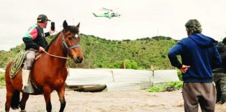 Residents airlifted to safety after flooding in central Chile A man on a horse takes a video of a helicopter hovering overhead. Another man stands nearby, with the water reaches his knees. The Mapocho river in central Chile burst its banks after heavy rains. JAVIER TORRES/EPA/SHUTTERSTOCK