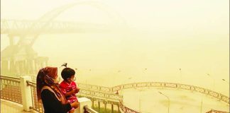 A mother and her child wearing facemasks look on from a bridge as thick haze from forest and land fires block their view of a region in Palangkaraya, Central Kalimantan, Indonesia. Persistent haze this year has prompted Indonesian authorities to step up efforts to punish offenders. GETTY IMAGES