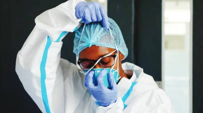 A nurse wears in white protective clothes and blue gloves at an Ebola isolation facility in Kenya. REUTERS