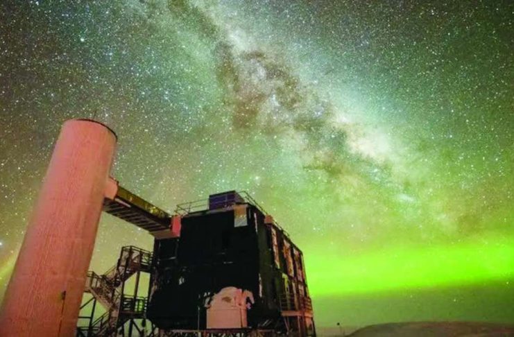 ‘Ghost particles’ from space telescope wins physics Nobel The Milky Way is seen through the middle, and the Northern Lights in green along the horizon. In the foreground is an observatory with a black building and stairs liking to a white column. YUYA MAKINO/ICECUBE/NSF