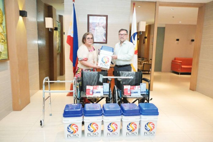 Philippine Charity Sweepstakes Office's (PCSO) General Manager Melquiades A. Robles (right) turns over medical devices and charitimba food packs to National Commission of Senior Citizens-National Capital Region's Commissioner Gloria Mercado.