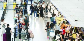 Passengers process their travel documents at airport counters. Airfare costs are expected to ease slightly from Oct. 16 to 31, 2026 after the Civil Aeronautics Board lowered airline fuel surcharges to Level 16, capping domestic add-on fees at P1,535 and international fees at P12,891.29 per passenger. INQUIRER PHOTO / NINO JESUS ORBETA