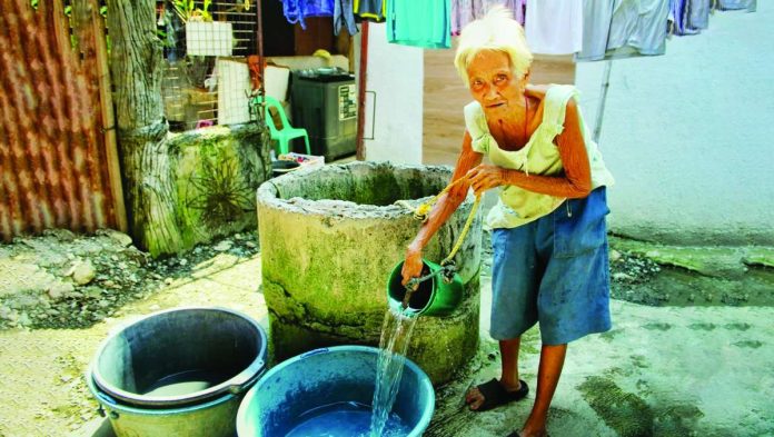 mai_wells_(1)-edited_compressed_resized A resident collects water form a shallow well for household use. Iloilo City intensifies its monitoring of wells amid preparations for a severe El Niño. Authorities warn that some water sources remain contaminated despite chlorination, posing potential health risks to families relying on groundwater. ALLEN ANIMAS/PN