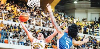 University of Santo Tomas Growling Tigers’ Kirk Cañete fends off the defense of Ateneo de Manila University Blue Eagles’ Travis Roberts as he drives for a layup during their UAAP Season 89 men’s basketball encounter. UAAP